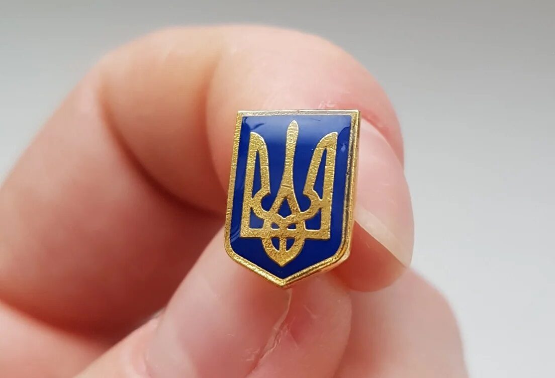 Sievietei norauj piespraudi Ukrainas karoga krāsās un nolamā