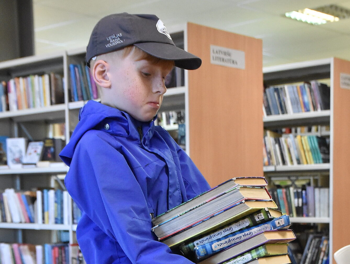 Foto: Bērnu bibliotēkas čaklajam apmeklētājam Pīteram ar grāmatu kaudzīti pietiek nedēļai
