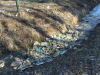 Sūdzas par netīrību atkritumu poligona apkaimē; uzņēmums vaino austrumpuses vēju un sola gružus savākt