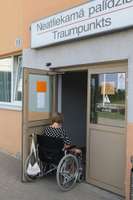 Cilvēks ratiņkrēslā iesprūst slimnīcas durvīs